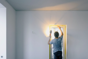 Man conducting home maintenance in a doorway